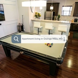 a pool table next to a kitchen with a search bar over top looking up Apartment living in Owings Mills, MD