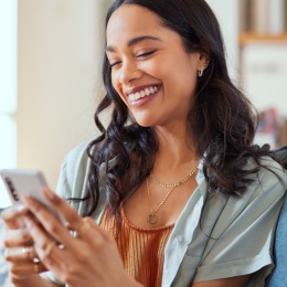 a person smiling looking at a phone